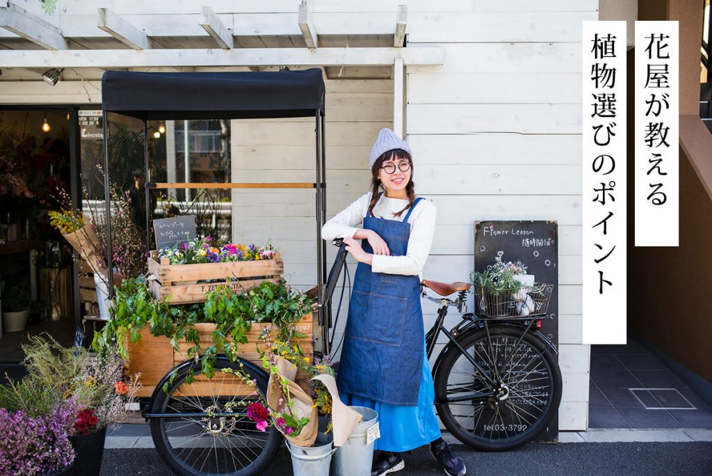 花屋の店員が店の前に立って